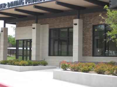 Academic building entrance featuring natural stone columns and brick walls